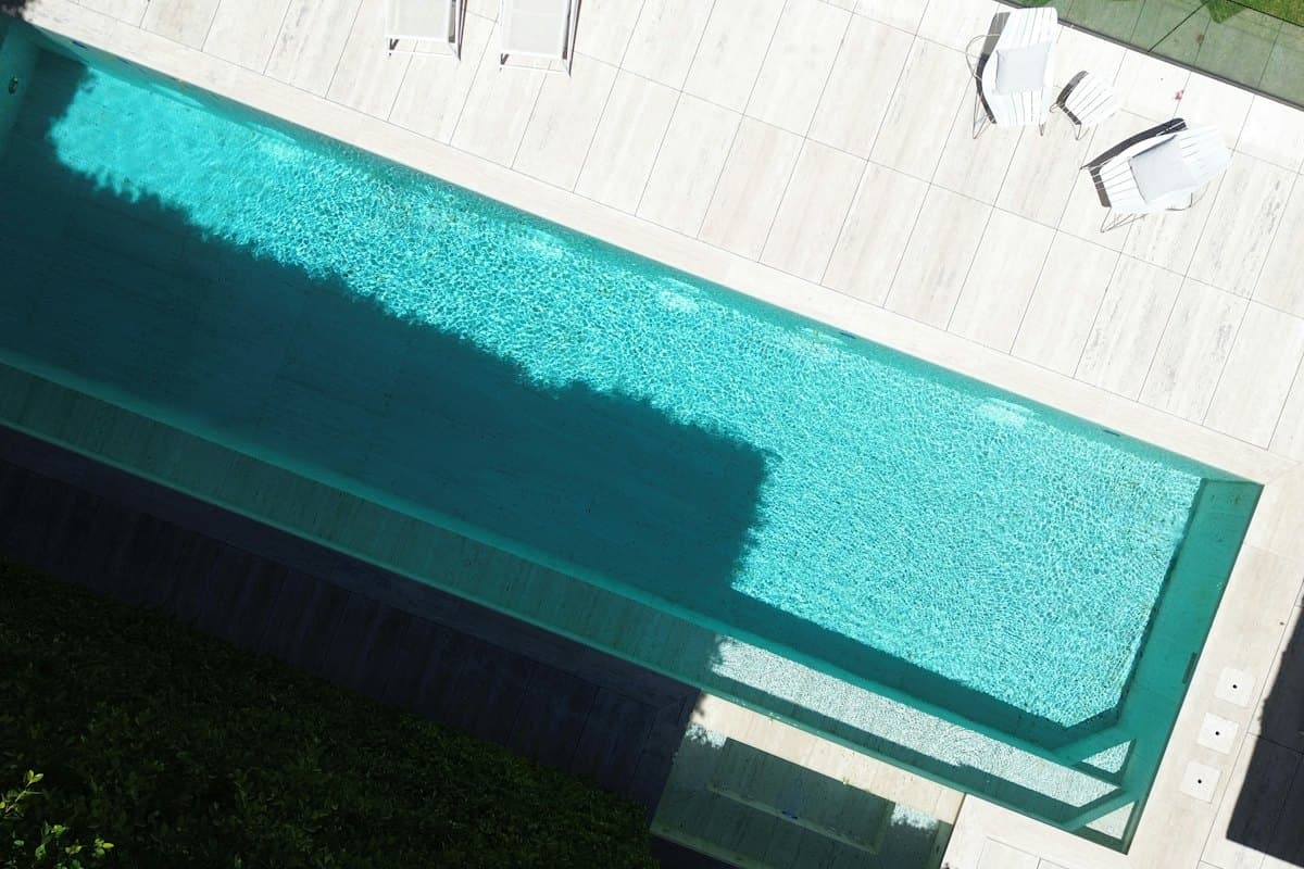 Aerial view of a residence and its turquoise pool