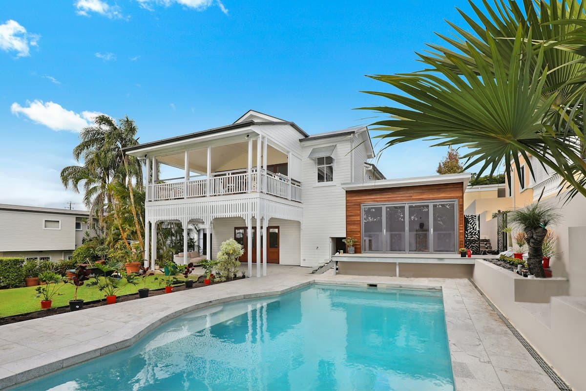White villa with a palm-lined swimming pool